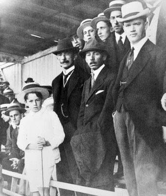 Santos Dumont ao meio, de chapéu preto.Santos Dumont ao meio, de chapéu preto. No lado esquerdo da imagem está o então presidente do Paraná, Afonso Camargo e ao lado direito o Eneas Marques, advogado e Secretário do Interior. O pequeno menino, de branco é o Alípio Camargo, futuramente empresário.​